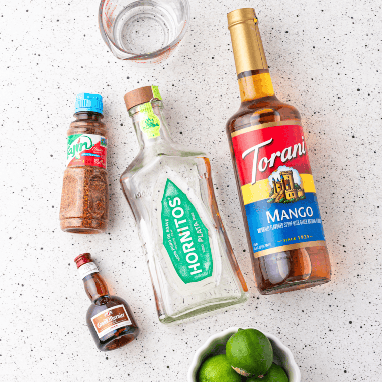 Fresh limes, blanco tequila, triple sec, agave nectar, and kosher salt laid out for a Ninja Slushi frozen margarita
