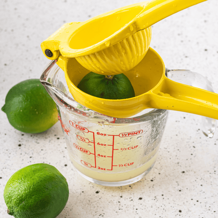 Margarita base being stirred in a glass pitcher until the agave fully dissolves