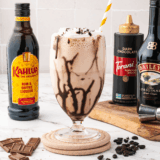 Ninja Slushi frozen mudslide dispensing from the tap into a chocolate-drizzled glass