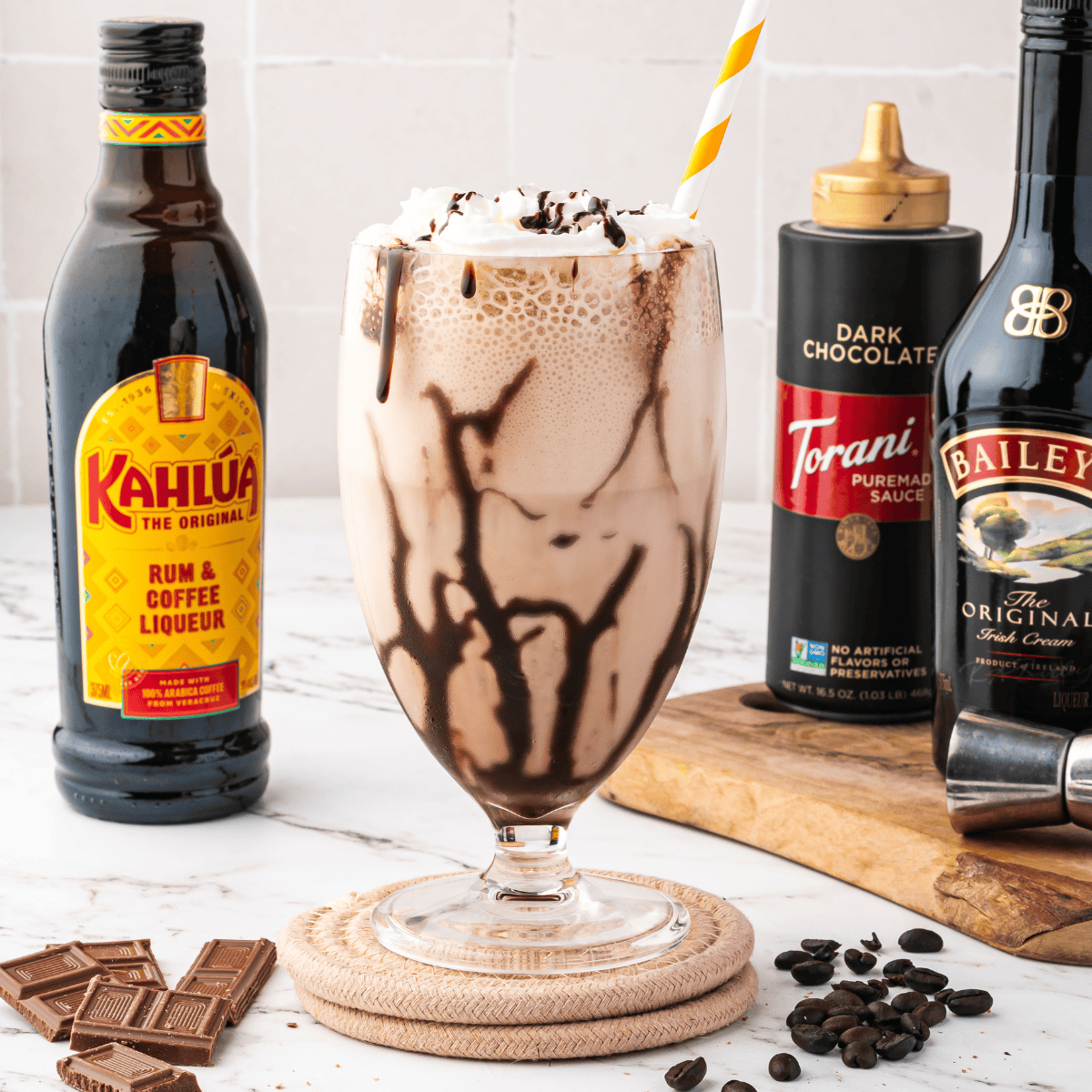 Ninja Slushi frozen mudslide dispensing from the tap into a chocolate-drizzled glass