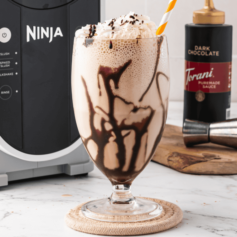 Ninja Slushi frozen mudslide in a chocolate-drizzled glass topped with whipped cream