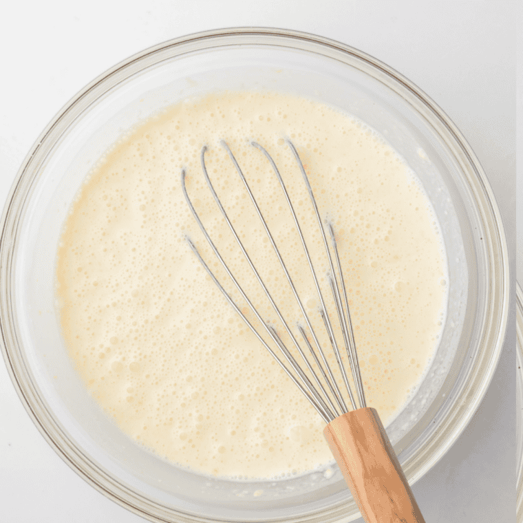 Vanilla ice cream, milk, and sugar whisked smooth in a glass measuring cup