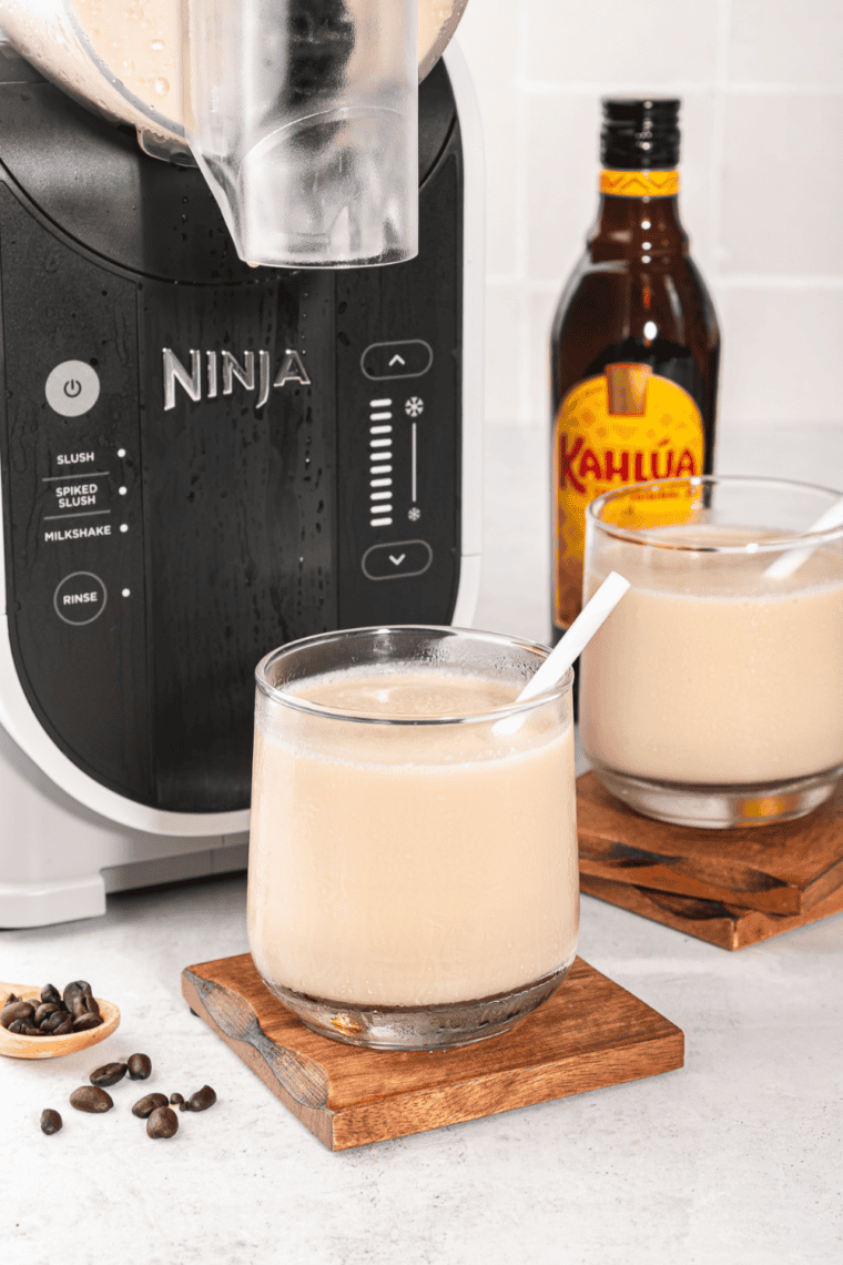 Frozen white Russian in a glass in front of the Ninja Slushi