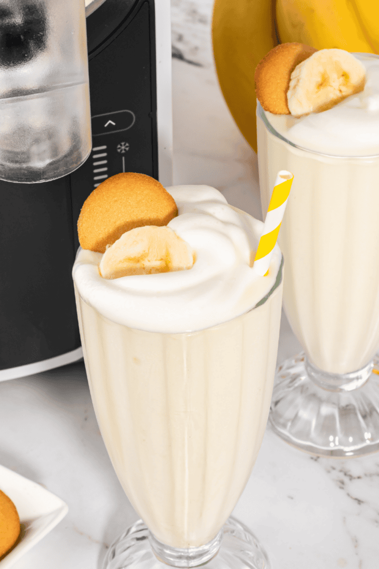 Two milkshakes in tall glasses in front of the Ninja Slushi