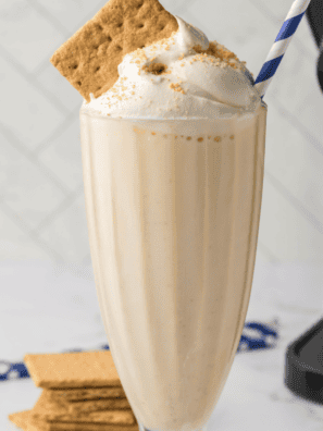 Thick vanilla milkshake made in the Ninja Slushi, poured into a tall glass with a wide straw