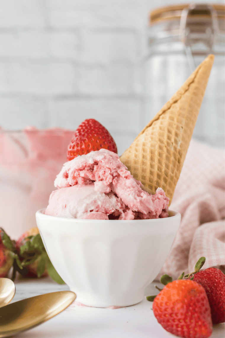 Bowl of Ninja Creami strawberry ice cream topped with fresh strawberries