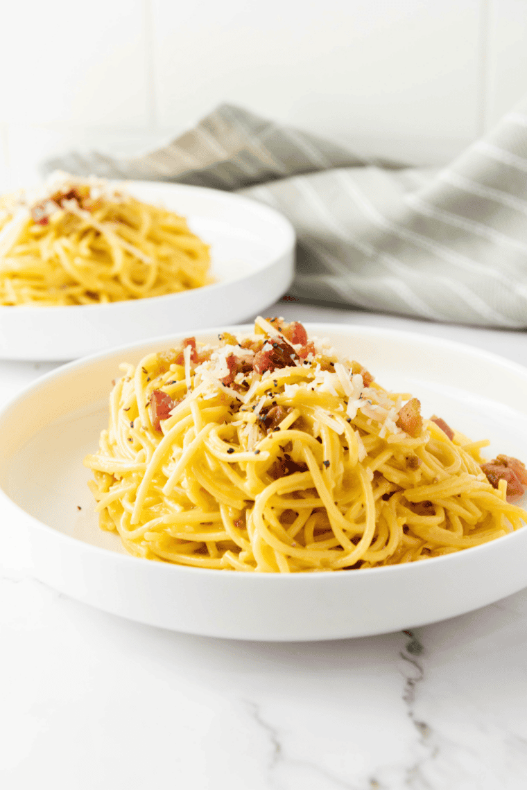 Twirled spaghetti in browned butter topped with a mound of grated mizithra cheese