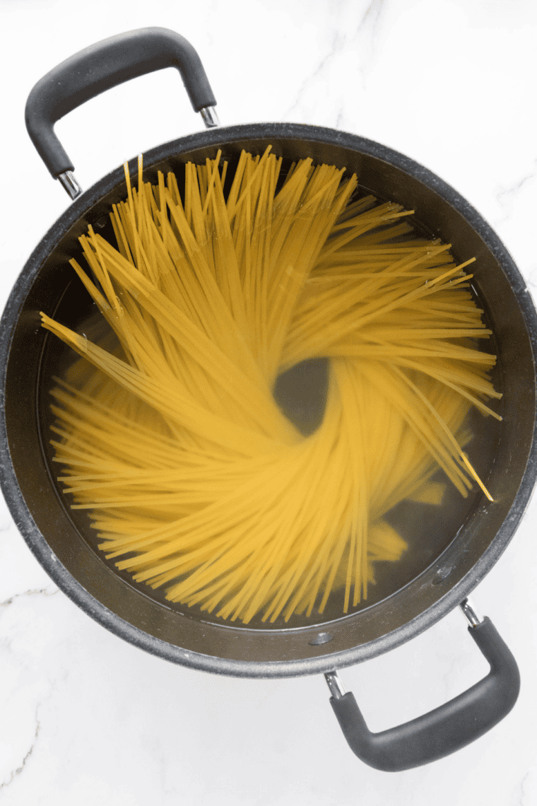 Spaghetti cooking in a large pot of salted boiling water