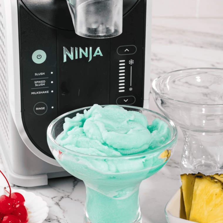 Bright blue frozen Blue Hawaiian drinks served alongside the Ninja Slushi that made them