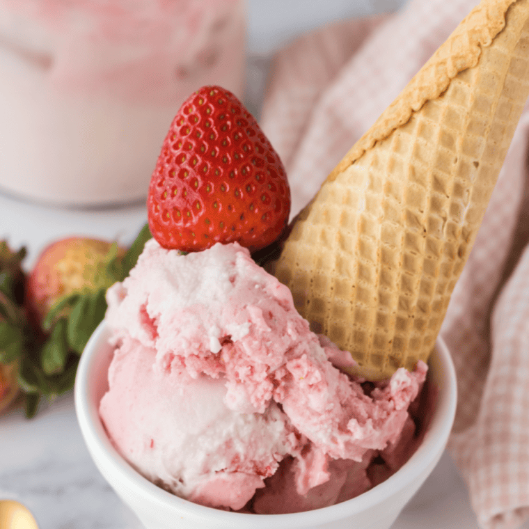 Ninja Creami strawberry frozen yogurt in a bowl, pale pink with flecks of real strawberry