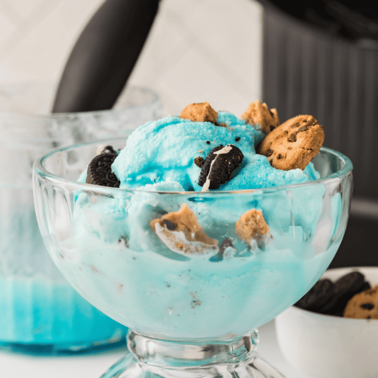 Bowl of bright blue Ninja Creami cookie monster ice cream loaded with chocolate cookie chunks