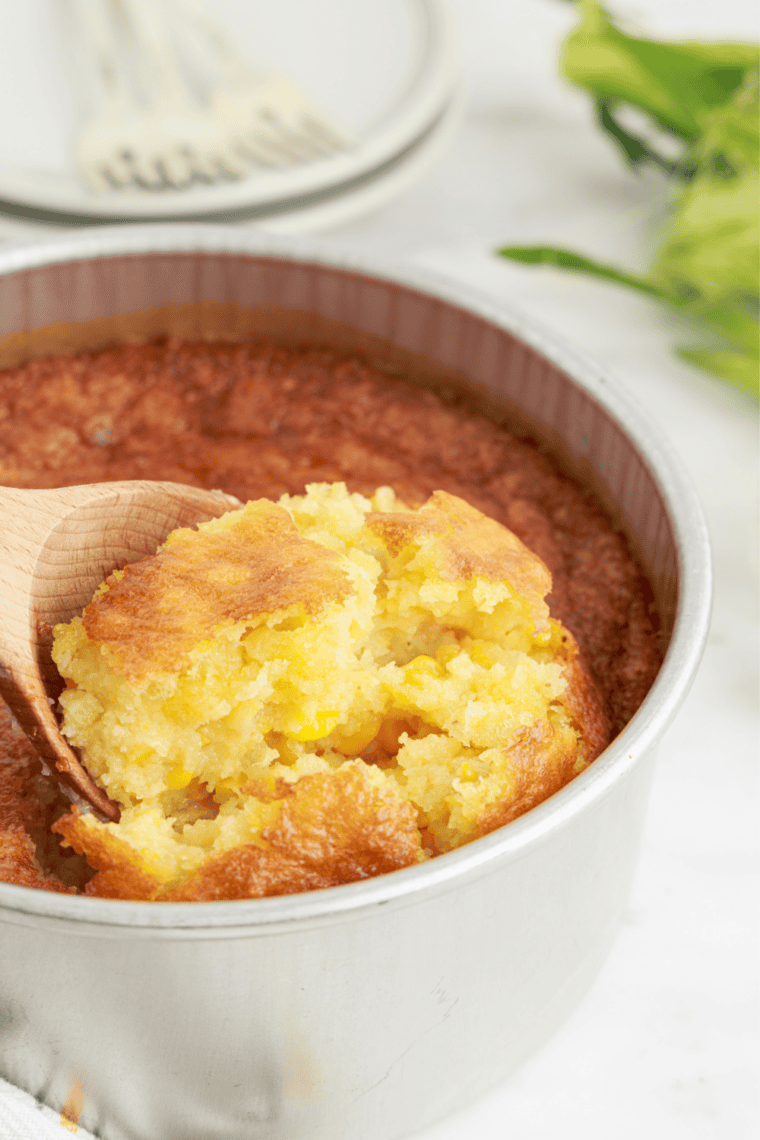 Creamy scoop of copycat 12 Bones Smokehouse corn pudding lifted from the baking dish
