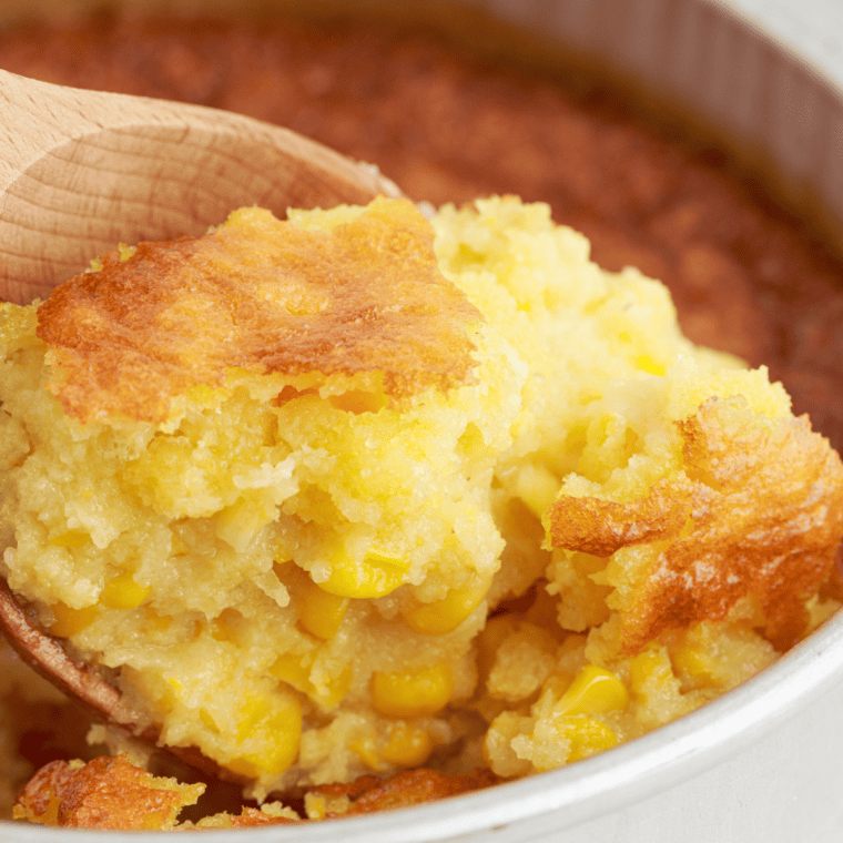 12 Bones Smokehouse copycat corn pudding in a baking dish with a golden top and one scoop removed