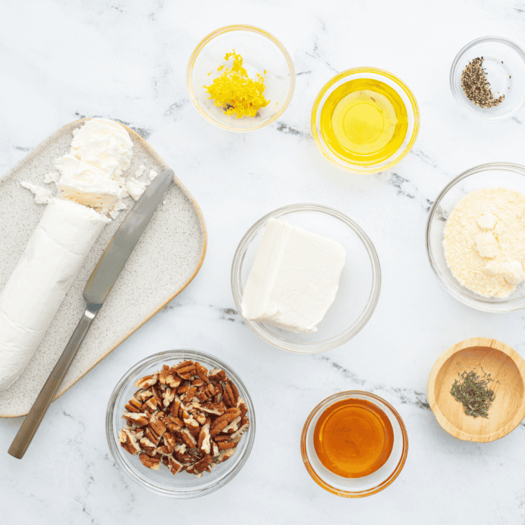 Ingredients for goat cheese dip including goat cheese, cream cheese, parmesan, pecans, honey, olive oil, thyme, and lemon
