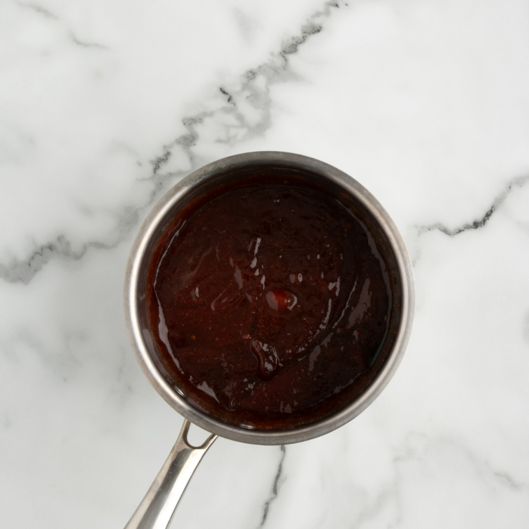 Tossing crispy air fryer wings in warm homemade Buc-ee's BBQ sauce
