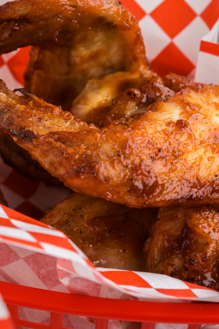 Air fryer BBQ chicken wings with a jar of copycat Buc-ee's BBQ sauce for dipping