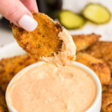 Air fryer Culver's fried pickles piled on a plate with a bowl of ranch