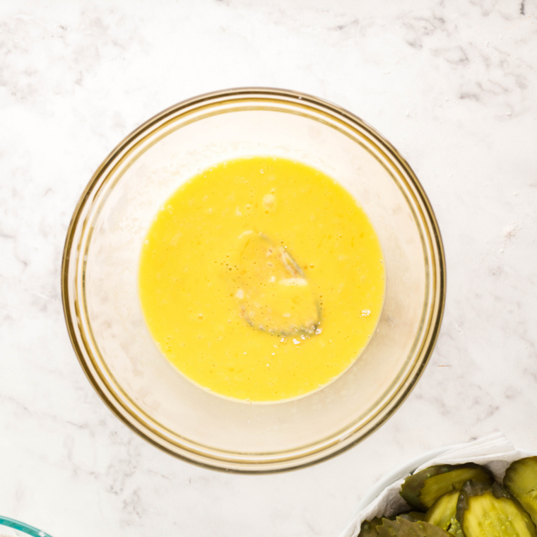 Bowl of egg and buttermilk wash for dipping breaded pickles