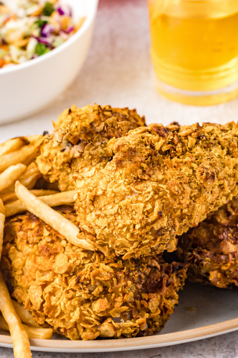 Plate of crispy golden fried chicken pieces and air fryer fries served on a dining table
