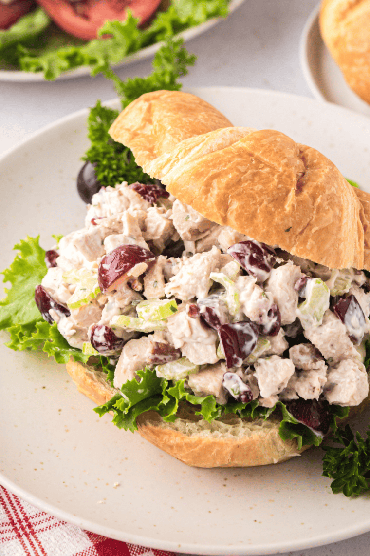 Amish hot chicken salad served on a croissant with a side of green beans