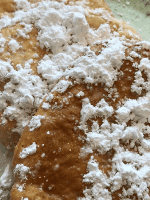Homemade Buc-ee's Beaver Tail recipe with icing drizzle on parchment paper