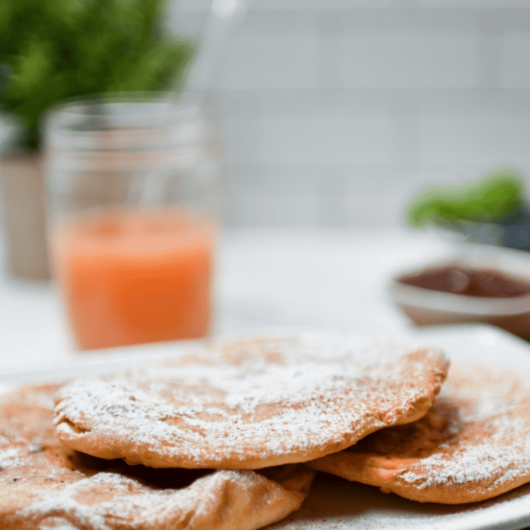 Close-up of powdered sugar icing drizzled over a warm copycat Buc-ee's Beaver Tail