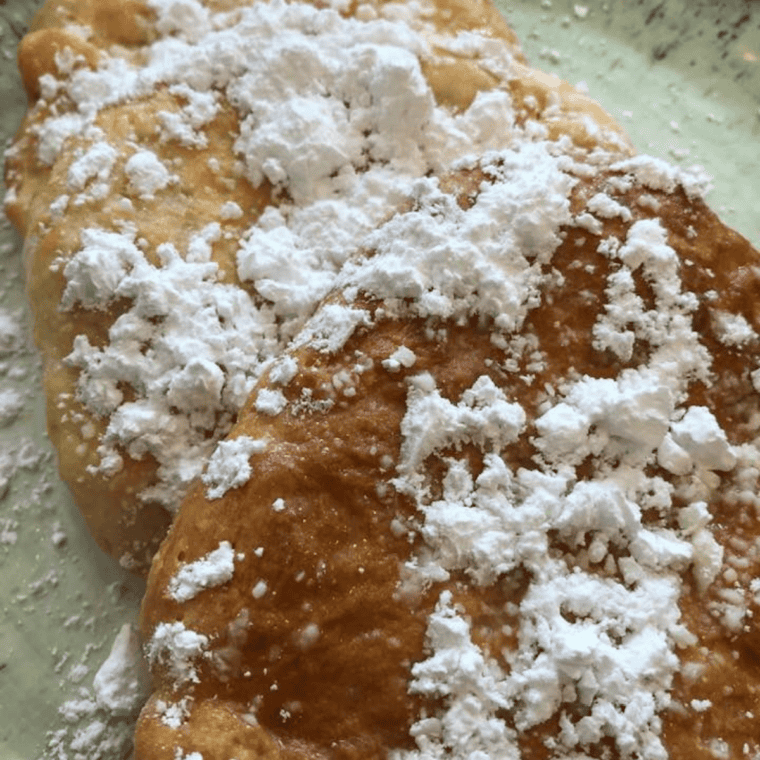 Homemade Buc-ee's Beaver Tail recipe with icing drizzle on parchment paper