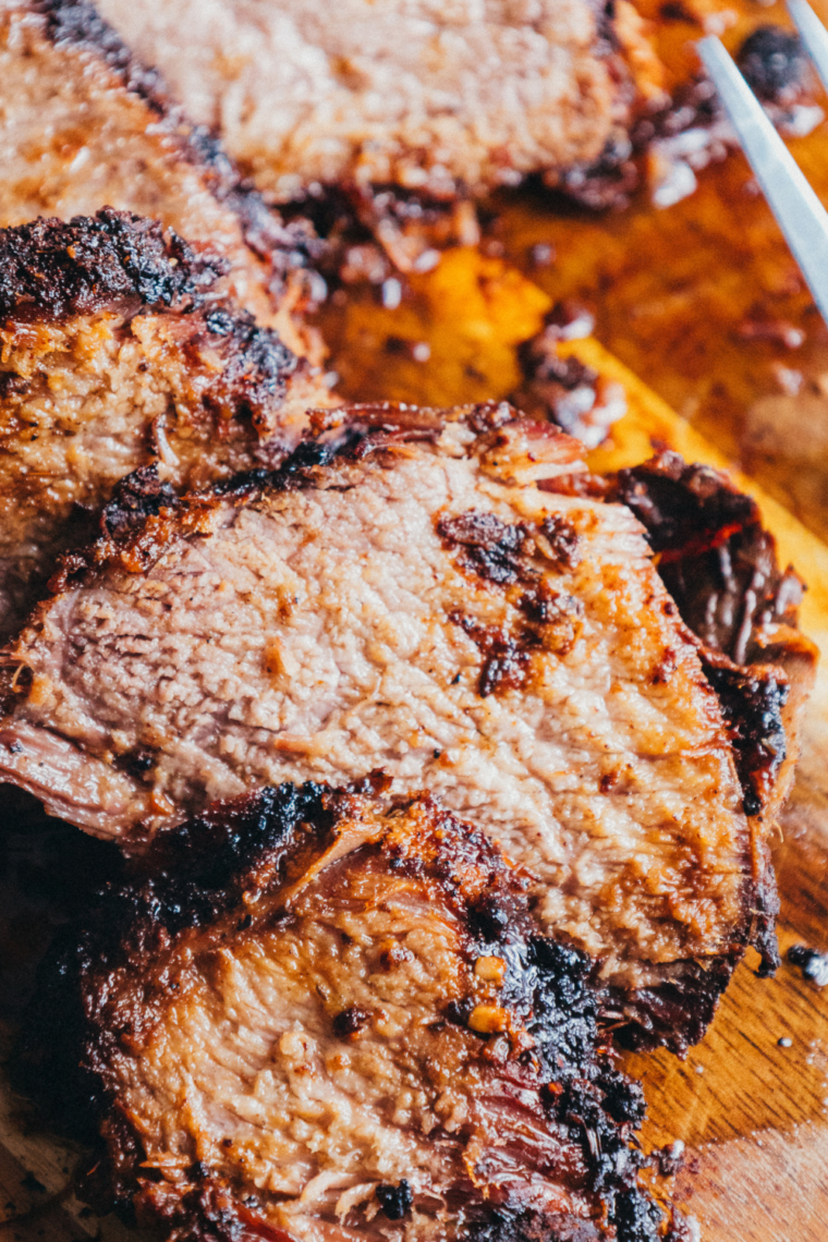 Close-up of a brisket slice showing a pink smoke ring and peppery crust