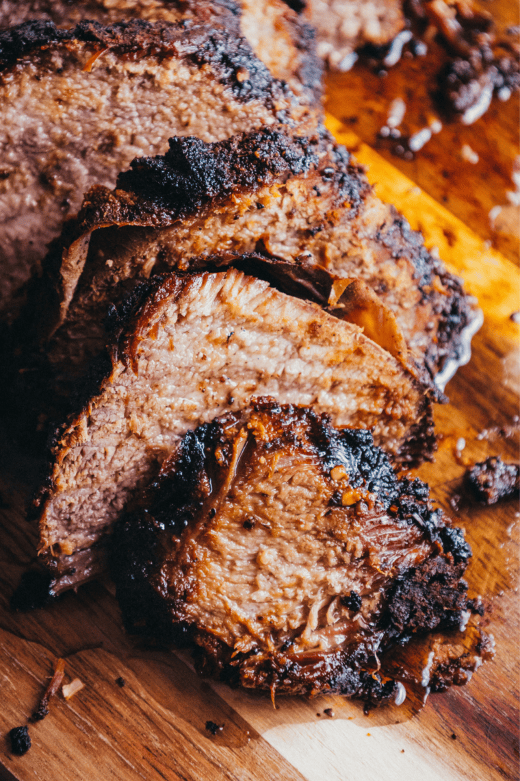 Slicing smoked brisket flat against the grain into pencil-thick slices