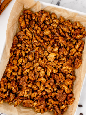 Copycat Buc-ee's candied almonds and cashews with a cinnamon sugar glaze on a parchment-lined baking sheet