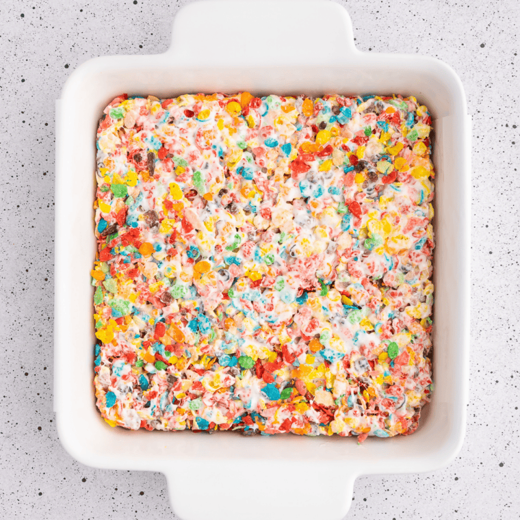 Set slab of Fruity Pebbles rice crispy treats lifted from the pan and cut into nine thick squares