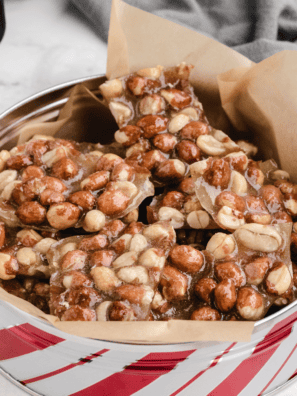 Copycat Buc-ee's pecan pralines stacked on parchment paper with pecan halves scattered around