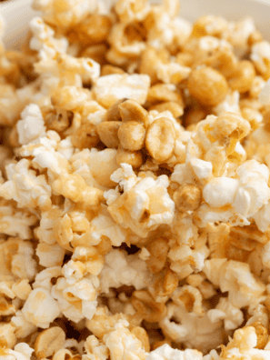 Copycat Buc-ee's popcorn kettle corn piled high in a large white bowl with loose kernels scattered on the counter
