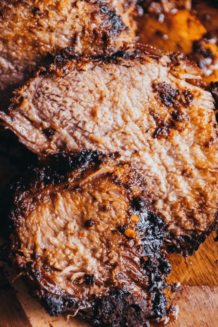 Sliced smoked brisket showing a smoke ring and seasoned crust