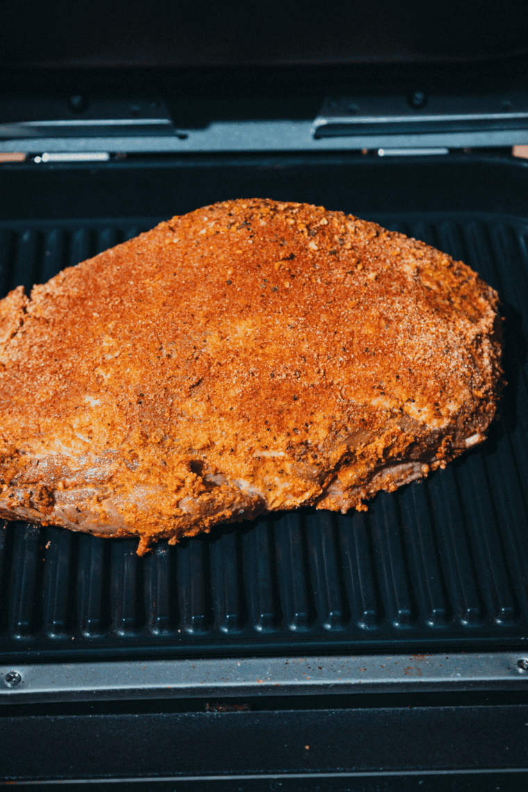 Raw trimmed brisket brushed with a thin layer of yellow mustard before seasoning
