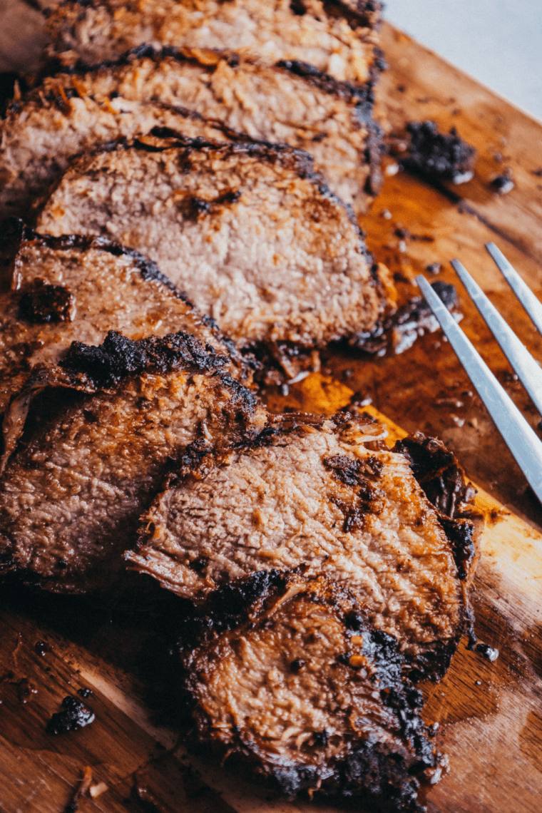 Seasoned brisket cooking on a smoker grill grate