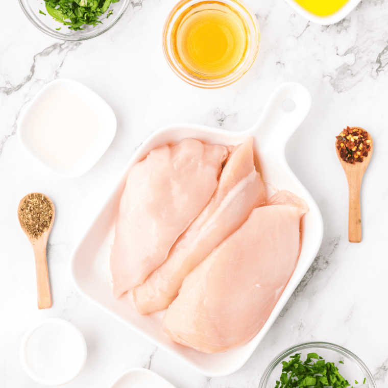 Ingredients for copycat Carrabba's Tuscan Grilled Chicken including chicken breasts, butter, garlic, lemon, and spices