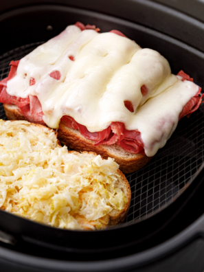Copycat Culver's Reuben melt cut in half showing corned beef, Swiss, and sauerkraut on toasted rye