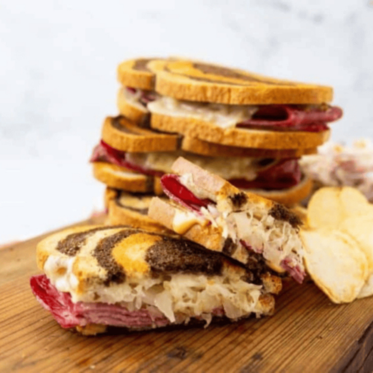 Close-up of a grilled Reuben showing melted Swiss and crispy rye crust