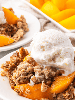 Copycat Kashi GoLean Crunch granola clusters in a white bowl with milk and sliced peaches.