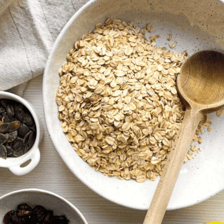 Rolled oats, crisp rice, almonds, and flaxseed mixed together in a large glass bowl
