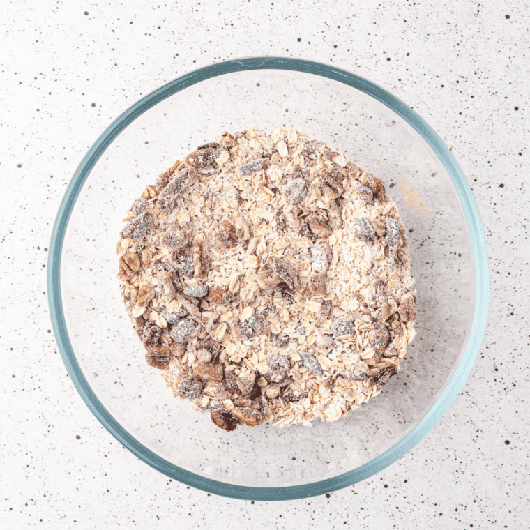 Rolled oats, protein crisps, peanuts, almonds, and protein powder combined in a large mixing bowl