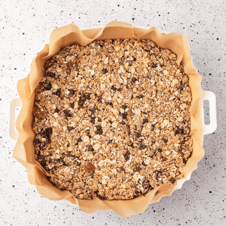 Protein granola mixture pressed firmly into an even layer on a parchment-lined baking sheet
