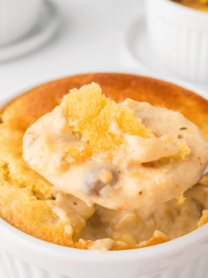 Copycat Perkins chicken pot pie in a crock with golden flaky puff pastry crust broken open to show creamy chicken and vegetable filling