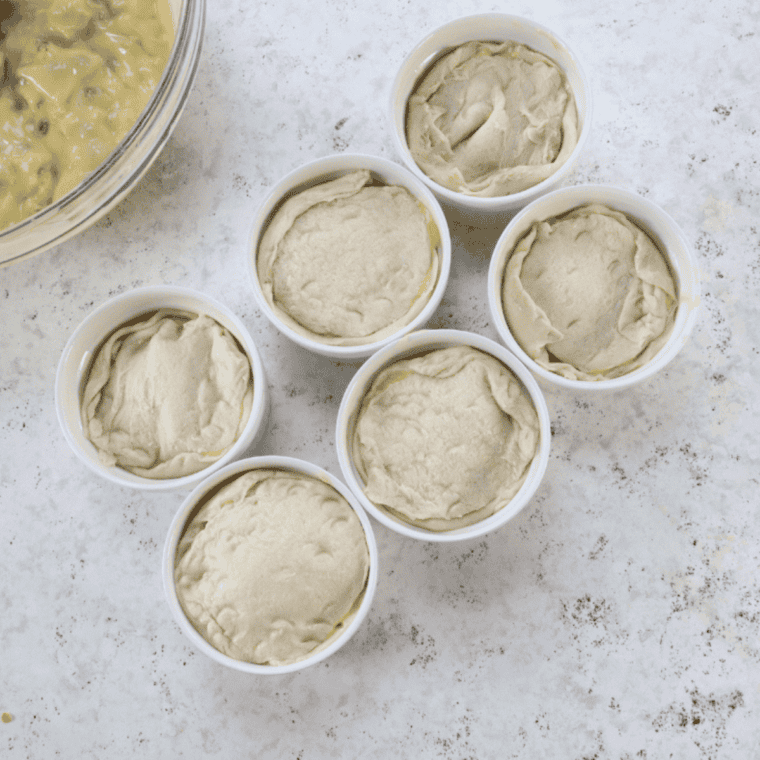 Draping puff pastry squares over ramekins and brushing with egg wash for copycat Perkins chicken pot pie
