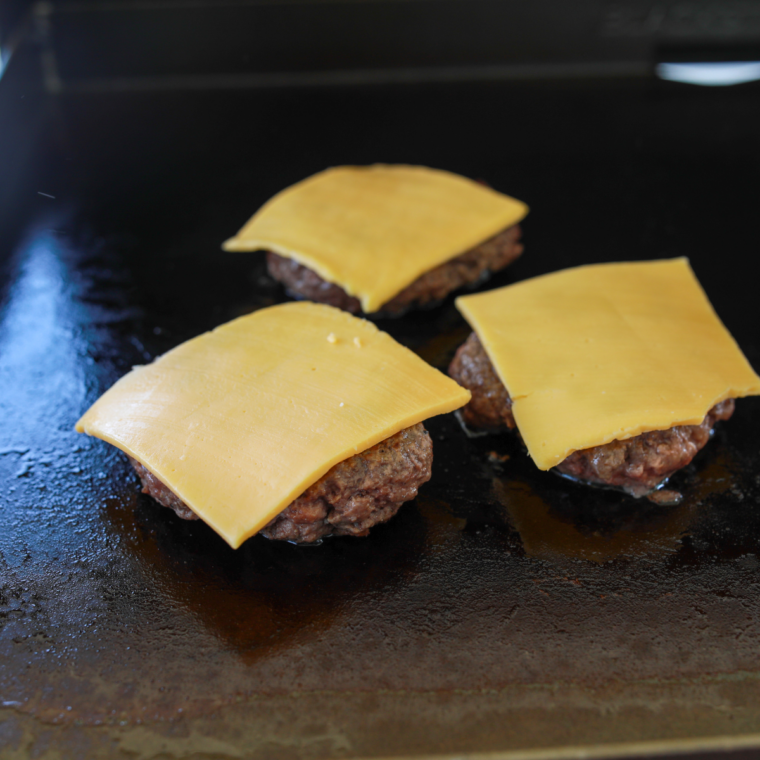 American cheese and grilled onions on a smashed burger patty