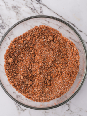 Bowl of copycat Steak 'n Shake Cajun seasoning with a spoon and paprika-red spice blend