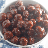 Chili sauce and cranberry sauce meatballs in a slow cooker with toothpicks
