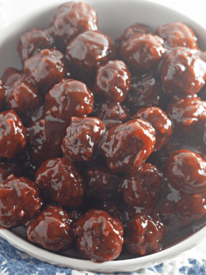 Chili sauce and cranberry sauce meatballs in a slow cooker with toothpicks