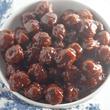 Chili sauce and cranberry sauce meatballs in a slow cooker with toothpicks